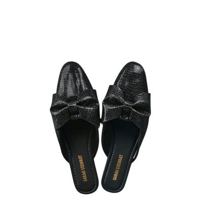 Shop Sarah Stewart black patent leather Beverly Bow Mules with lizard embossed texture and decorative bow detail