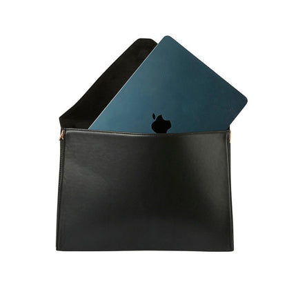 Shop Sarah Stewart black vegan leather laptop clutch with a dark blue laptop inside and gold hardware details.