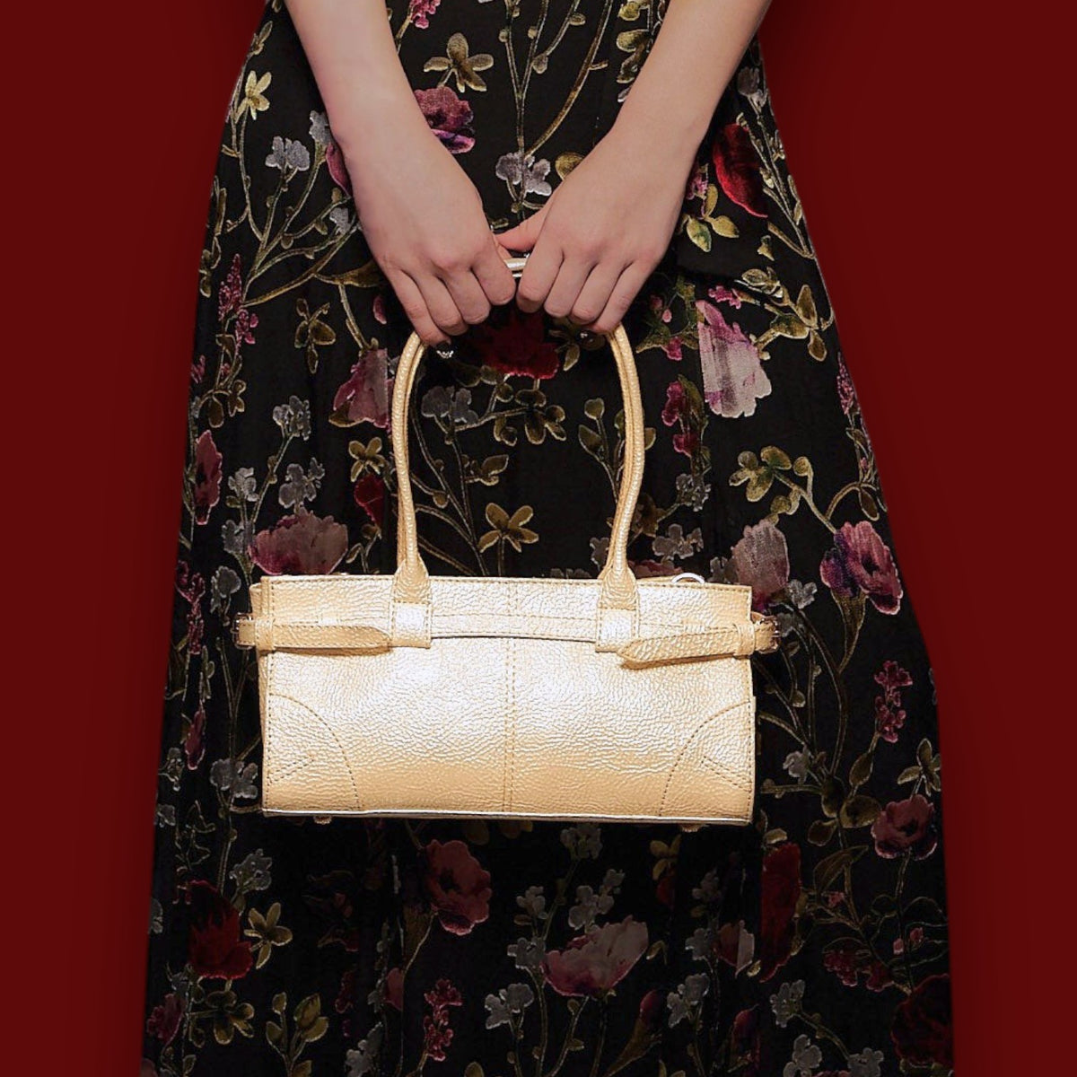 Shop Sarah Stewart The Paris gold lambskin shoulder bag with metal hardware held by a person in a floral dress