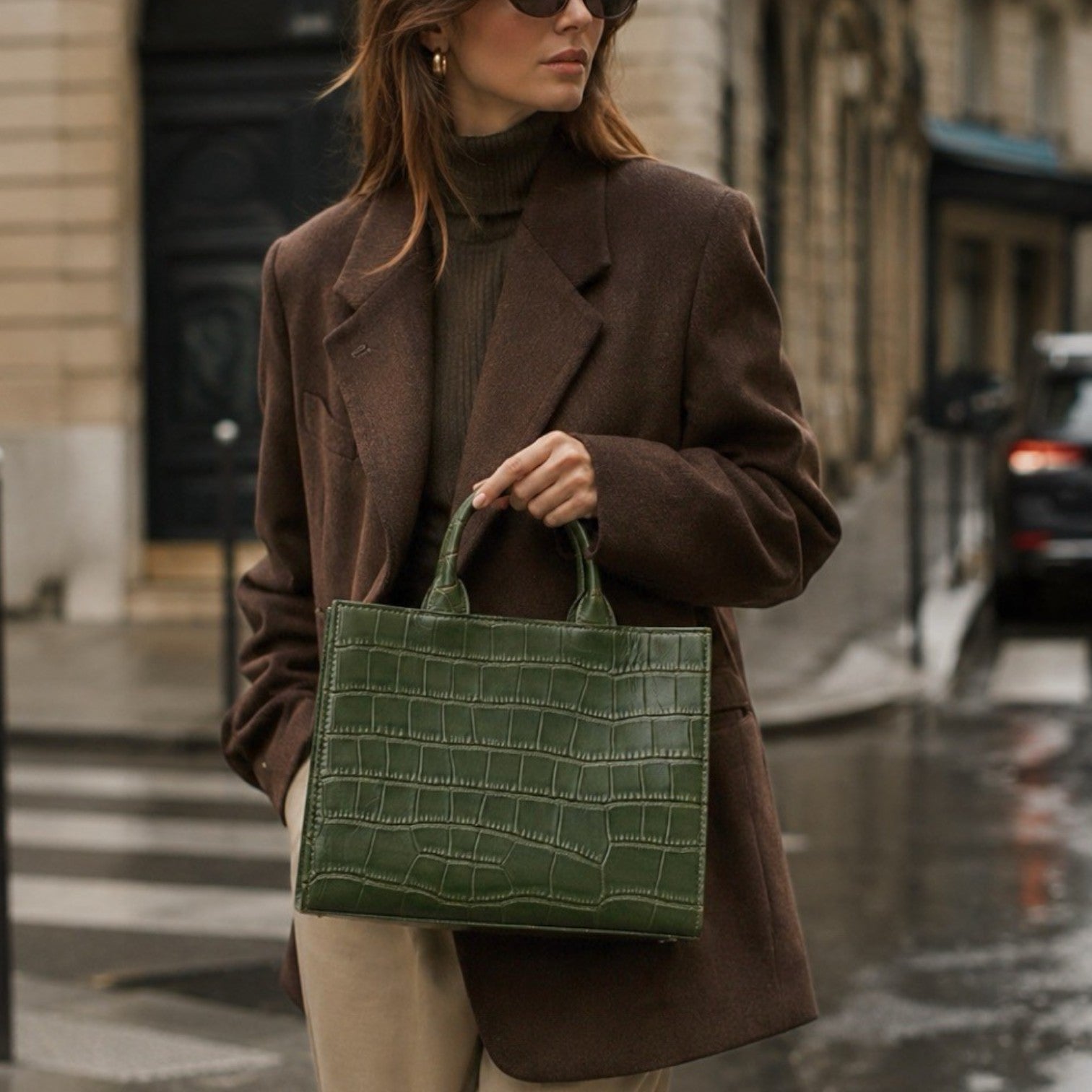 Shop Sarah Stewart Adele handbag in green croc-embossed lambskin leather held by a woman in a brown blazer