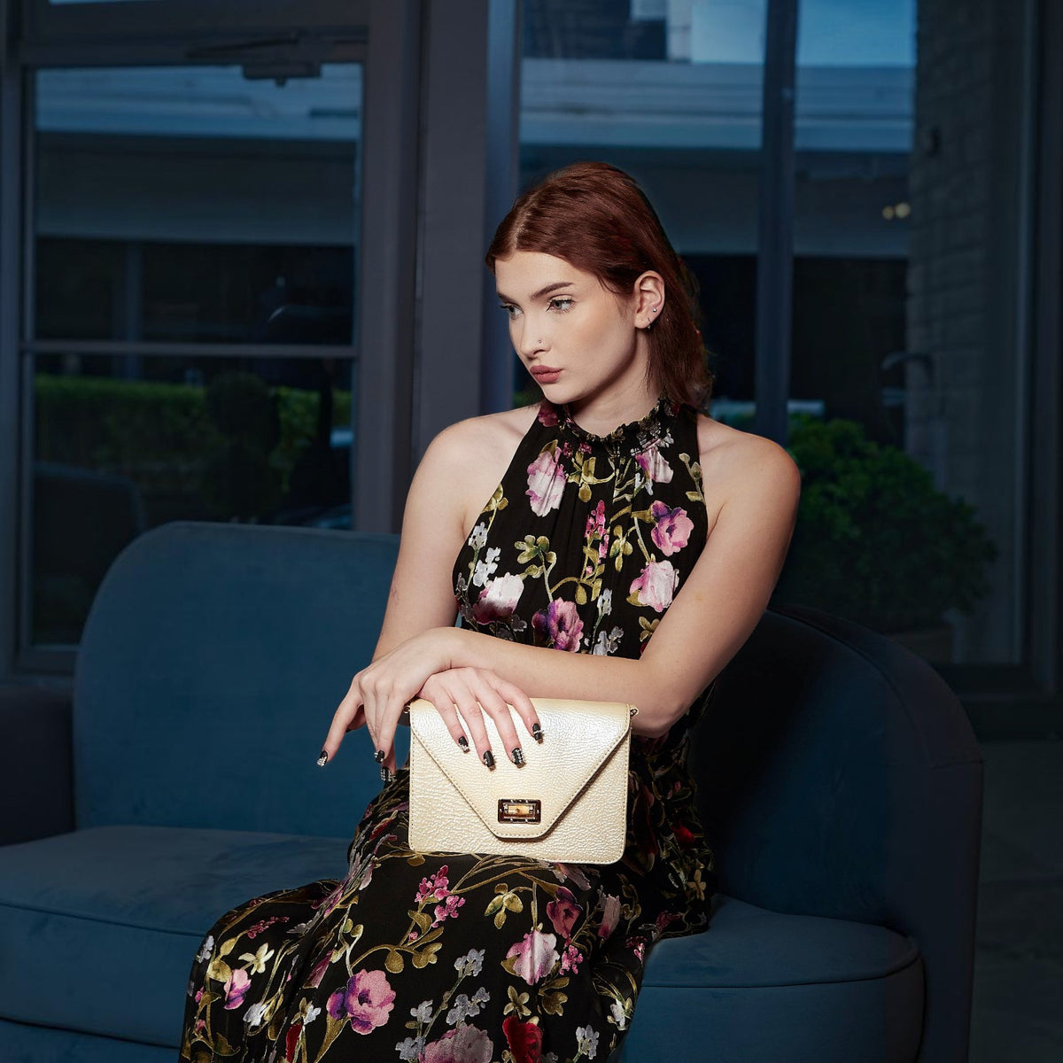 Shop Sarah Stewart Stacey Patent lambskin shoulder bag with bamboo closure held by a woman in a floral dress