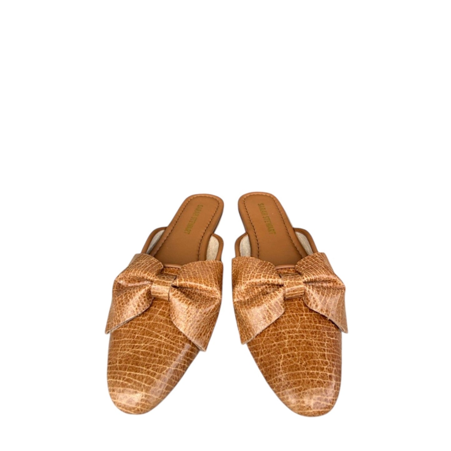 Shop Sarah Stewart Beverly Bow Mule in tan patent leather with a lizard embossed texture and decorative bow detail.