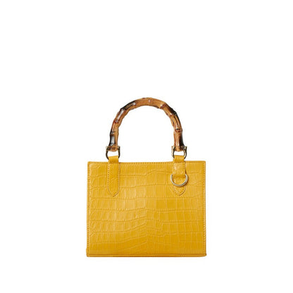 Shop Sarah Stewart Clara mini handbag in yellow goat skin leather with a crocodile texture and bamboo top handles.